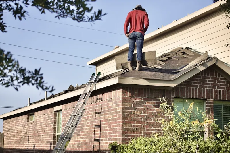 Professional roofer working on a residential roof in Normandie
